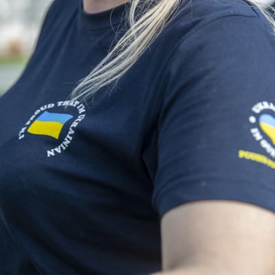 naisella on yllään t-paita, jossa on Ukrainan lippu ja lukee "I'm proud that I'm Ukrainian"