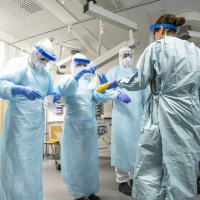 Personalen vid Kuopio universitetssjukhus övar hur man klär på sig och använder skyddsdräkt.