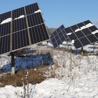 Solpaneler på ett av snö täckt fält i Tyskland