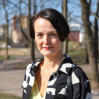 Nainen katsoo kameraa kohti.