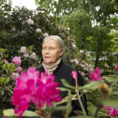 Suunnitteluhortonomi Sirpa Nieminen seisoo kukkien keskellä.