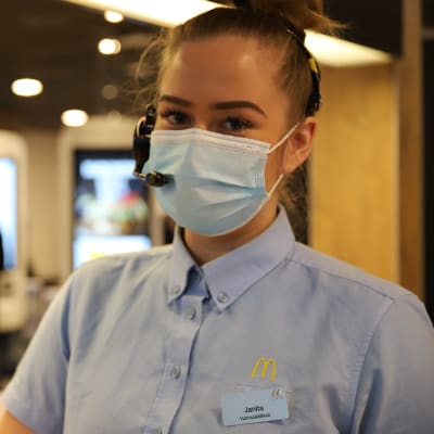 Kasvomaskiin ja vaaleansiniseen työpaitaan pukeutunut McDonald'sin esimiesharjoittelija Janita Koskenheimo.