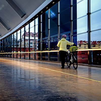 Logomobron från insidan. En person leder en cykel längs med gången. 