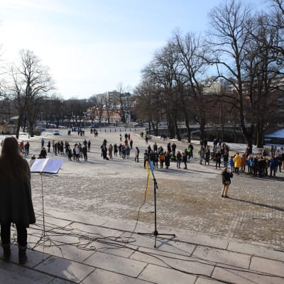 Ukrainamielenosoitus Turun tuomiokirkon edustalla. Ihmisiä puhumassa portailla yleisölle.