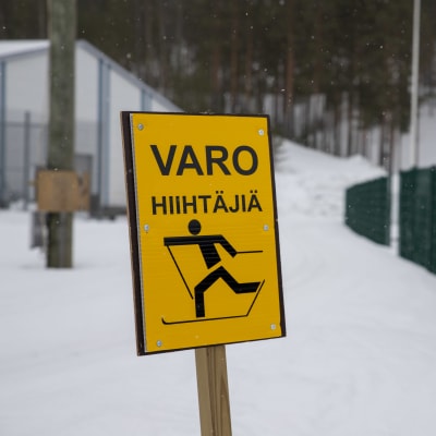 hiihtoladun varreessa seisoo kyltti, jossa lukee "varo hiihtäjiä"