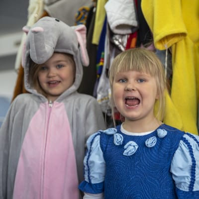 Päiväkodin lapset Enni Markola ja Lotta Piiparinen ovat pukeutuneet rooliasuihin. Ennillä on norsupuku ja Lotalla sininen prinsessa-asu.