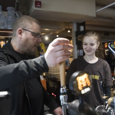 Alepupin työntekijä opettaa opiskelijaa käyttämään juomalaitteita.
