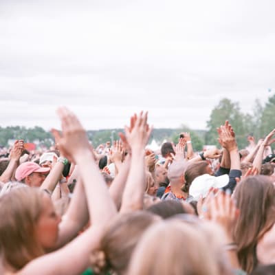 Yleisöä Käärijän keikalla Ruisrockissa 2023. Ihmisillä on kädet ylhäällä. 