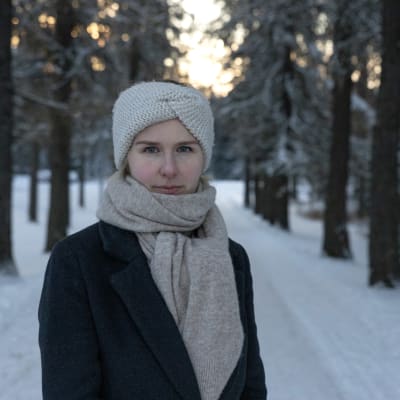 Nainen katsoo kameraan.