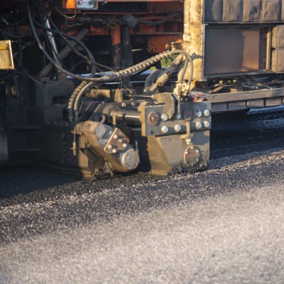 asfalttikone levittää tien pintaan kierrätysasfalttia