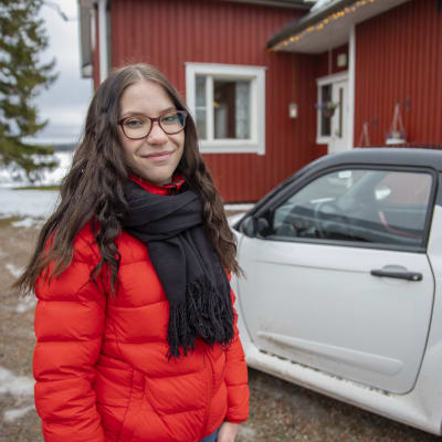 Juulia Ketola mopoautonsa kanssa kotitalon edustalla.