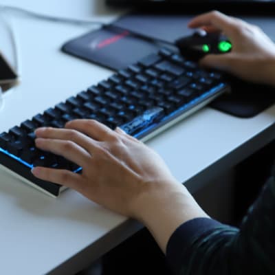 Naisen kädet tietokoneen näppäimistöllä.