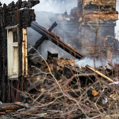 Tulipalossa tuhoutuneet talon savuavat rauniot.