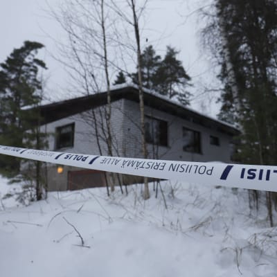 Poliisiteippi estää pääsyn tutkintapaikalle Veikkolassa Kirkkonummella. Taustalla talo, johon neljän kuolleen tapaus liittyy.