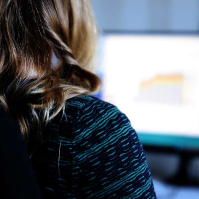 En kvinna sitter framför en datorskärm.