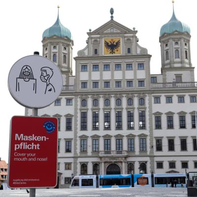 Skylt infomerar om att det är obligatoriskt att bära munskydd utanför rådhuset i Augsburg