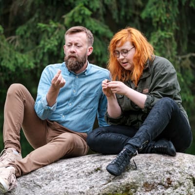 Naturväktarnas programledare Annika Ljungberg och Joakim Lax sitter på en sten.