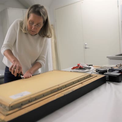 Taidekonservaattori Nina Robbins vaihtaa maalaukseen kiilakehystä