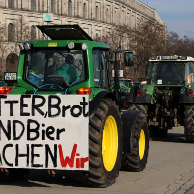Traktorer i en protestkö. En av traktorerna har en skylt med "smör, bröd och öl är det vi äter".
