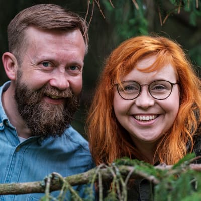 Närbild av Annika Ljungberg och Joakim Lax på en sten i skogen.