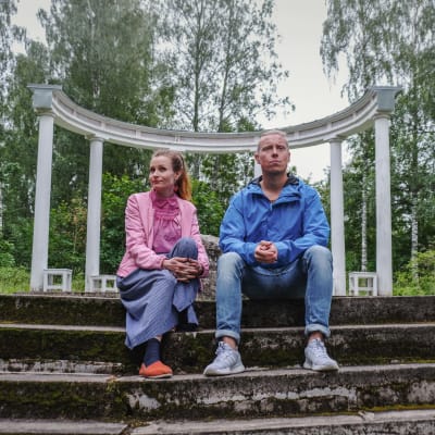 Hannamari Hoikkala ja Nicke Aldén istuvat portailla, taustalla valkoisia pylväitä
