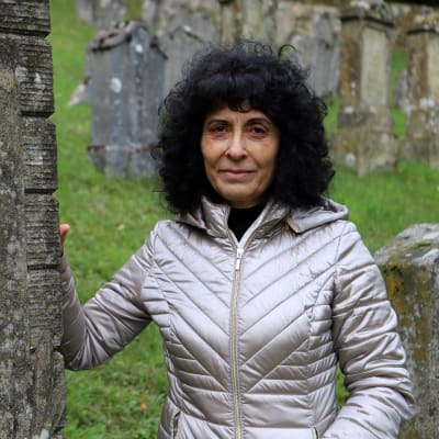 Rajaa Nadler står vid en gravsten på den judiska begravningsplatsen i Ermreuth