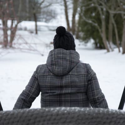 Nainen istuu keinussa