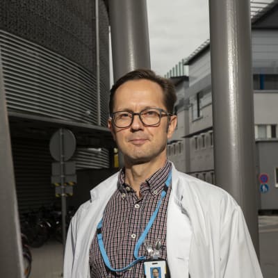 Läkaren Matti Reinikainen utanför en sjukhusbyggnad. 