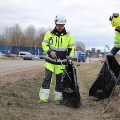 YIT:n Teemu Lavikka ja Toivo Lavikka keräämässä roskapihdeillä roskia jätesäkkeihin Kotkan Sutelassa.