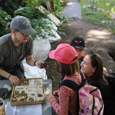 Barn ser på fynd från arkeologiska utgrävningar.