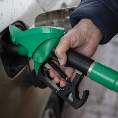 Henkikö pitelemässä bensapumppua ja tankkaamassa autoaan.
