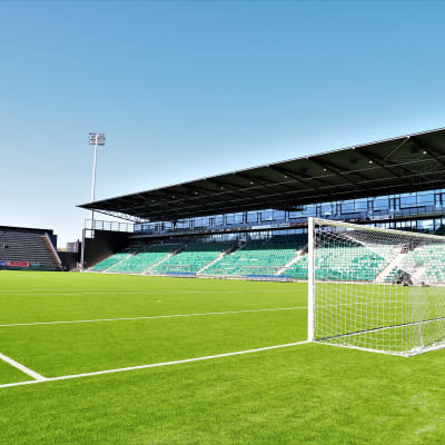 Kuppis fotbollsstadion. På bilden syns en konstgräsplan, ett mål och i bakgrunden en läktare.