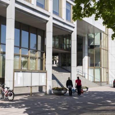 Kouvolan kaupungintalolle kävelevät henkilöt.