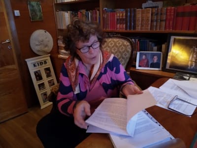 Brita Kristina Gyllenbögel läser en bunt med papper.