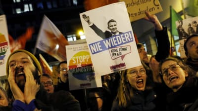 Personer håller i plakat och protesterar i Tyskland. 