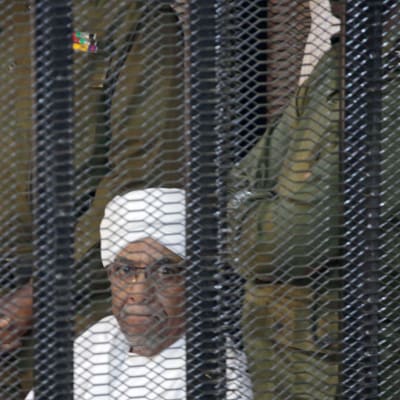 Sudanin entinen presidentti Omar al-Bashir seuraa oikeudenkäyntiään vankikopista Khartoumissa.