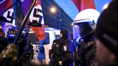 Demonstranter med nazistflaggor och poliser.