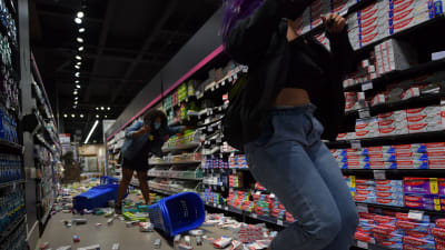 Demonstranter fäller ner produkter i en mataffär på golvet i samband med Black Lives Matter-demonstrationer i Sao Paulo 20.11.2020.