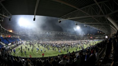 Fotbollsplanen vid Tölöstadion full med människor efter Finlands fotbollsmatch mot Liechtenstein.