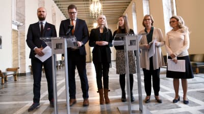 Touko Aalto (Gröna), Antti Lindtman (SDP), Laura Huhtasaari (Sannf), Li Andersson (VF), Anna-Maja Henriksson (SFP) och Päivi Räsänen (KD) står på rad i rikssalen. 