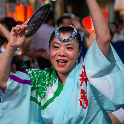 Yukata-asuun pukeutunut nainen juhlii festivaalilla Japanissa.