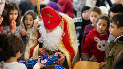 Tysklands version av julgubben St. Nicholas delar ut gåvor till syriska flyktingbarn vid en förläggning i Friedland, Tyskland den andra december 2016.