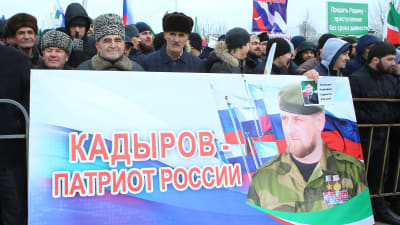 Män håller upp skylt med texten Kadyrov - en rysk patriot.