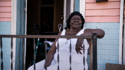 86-åriga Symentress Calloway sitter på balkongen till sin bostad i New Orleans.