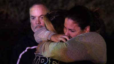Två personer kramar varandra utanför baren där 13 personer skjutits ihjäl i Thousand Oaks.