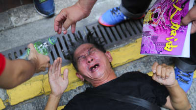 Demonstranter hällde vatten i ansiktet på en man som plågades av tårgasen under söndagens demonstration. 