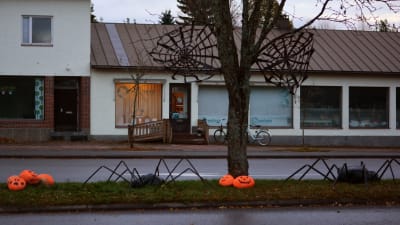 En gata är dekorerad med halloweenpumpor, spindlar och spindelväv.