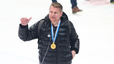 Pekka Virta ger tummen upp med en guldmedalj runt nacken.