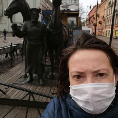 En selfie av Vera Saltanova med munskydd framför en staty i S:t Petersburg.