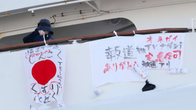 En passagerare ombord på Diamond Princess hänger upp ett lakan med texten "allvarlig brist på mediciner."